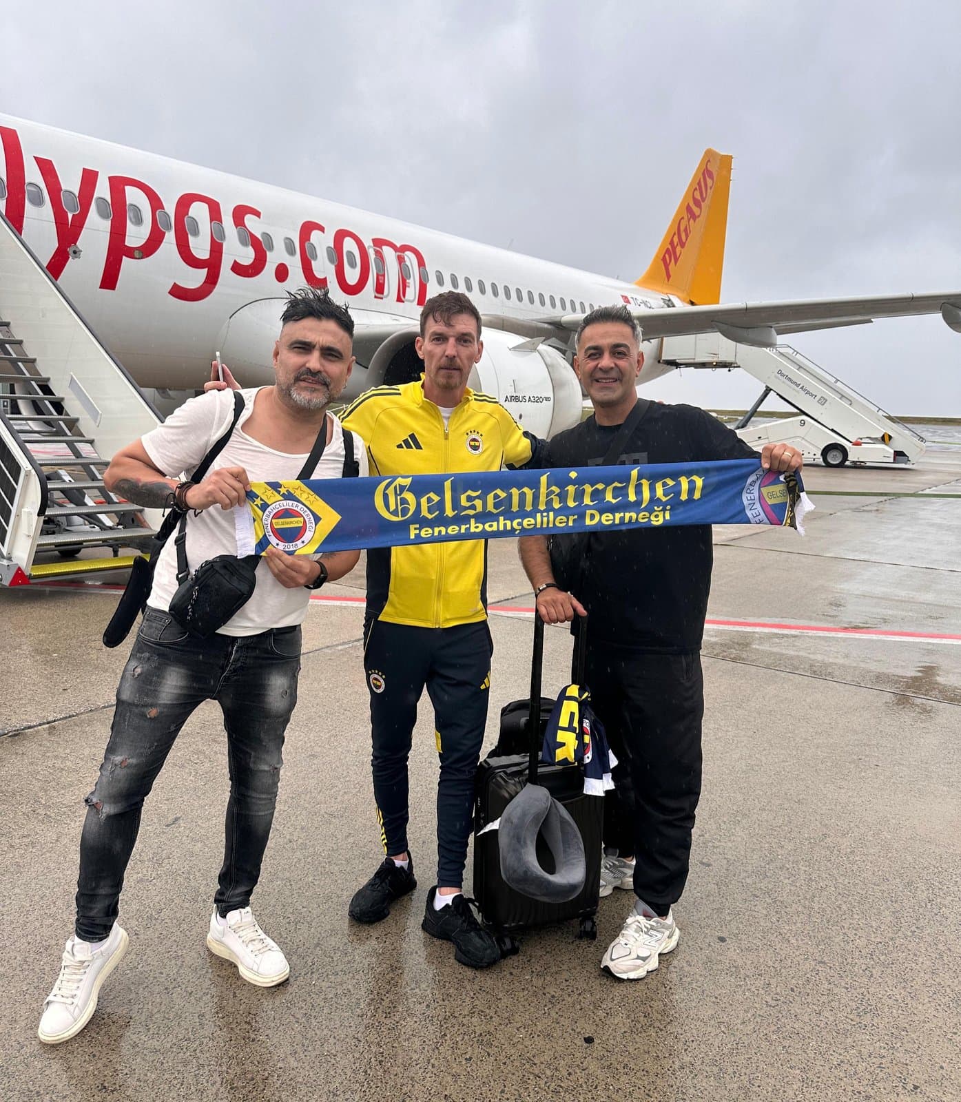Vereinsmitglieder mit Gelsenkirchen-Schal vor dem Flugzeug